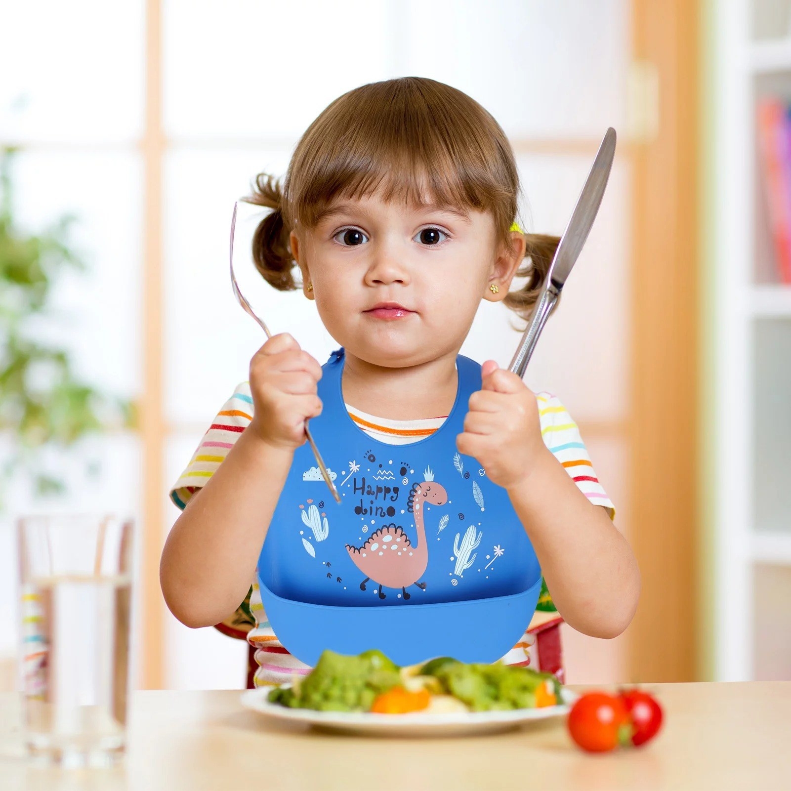 Toddler eats while wearing bib
