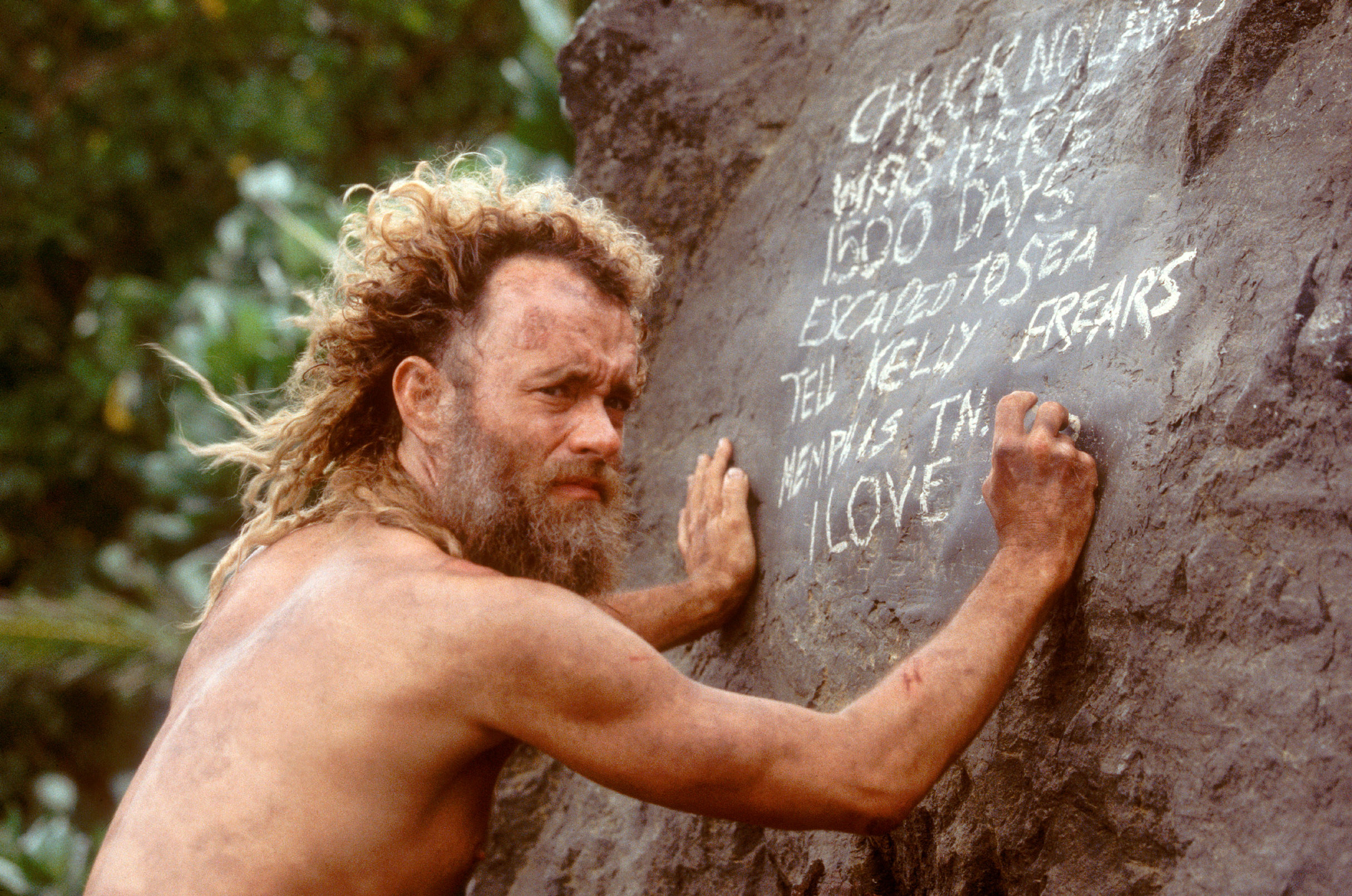 Tom Hanks writes a message on a rock face for future rescuers before he attempts to finally leave the island on a raft