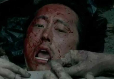 Glenn bloodied and surrounded by zombie hands