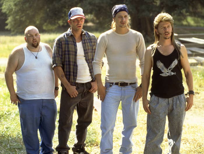 Characters from Joe Dirt, including David Spade and Kid Rock, standing on the grass