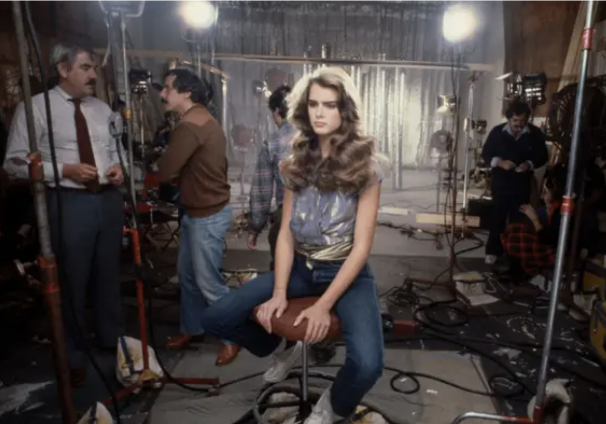 brooke shields sits on a stool in the middle of a film set