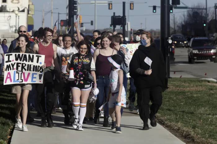 a group of protesters walk down the street
