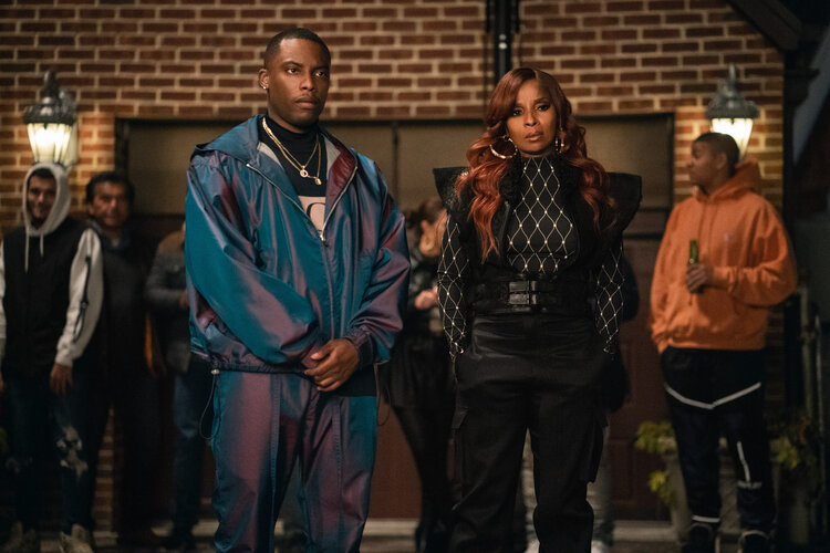 Cane (Woody McClain) in a shiny tracksuit and Monet standing and looking intense