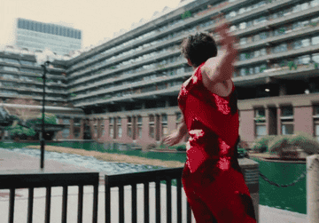 a gif of Harry Styles dancing and running through a gate