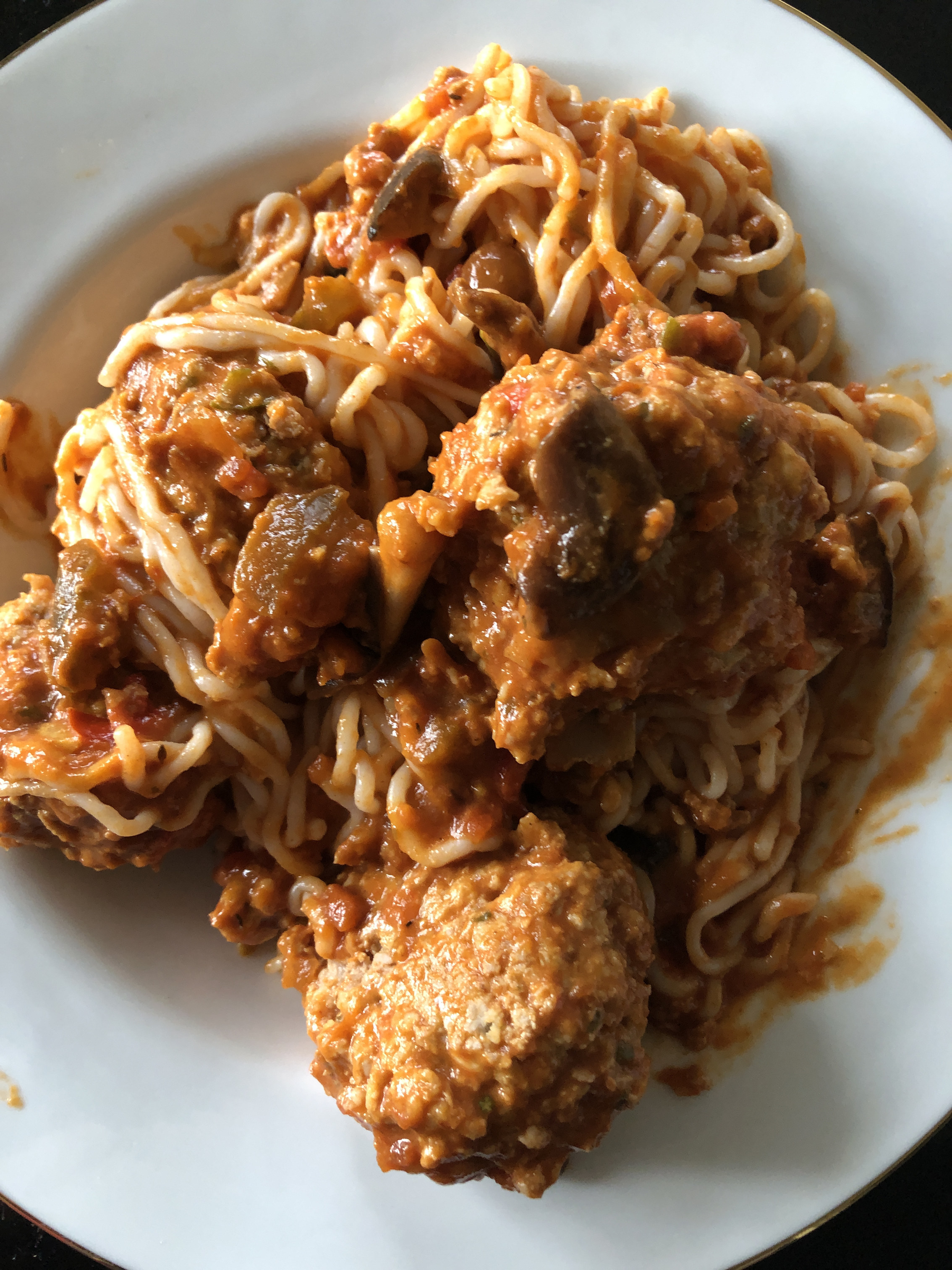 plate of turkey meatballs in tomato sauce, served over spaghetti and sauce