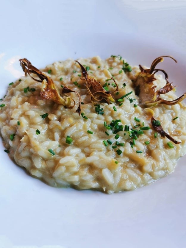 risotto neatly spooned into a serving bowl, garnished with chives