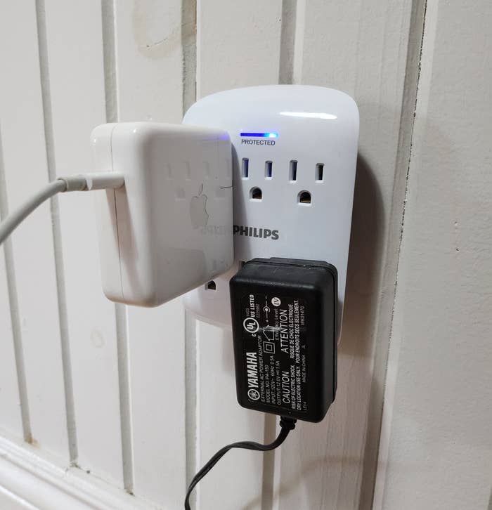 a philips outlet extender with two chunky plugs plugged into it