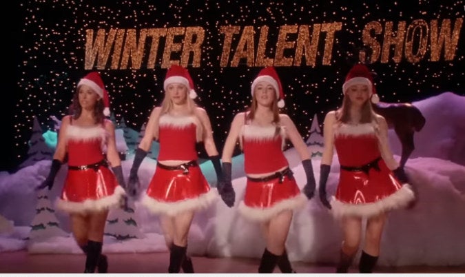 the group of friends in short santa skirts dancing on stage