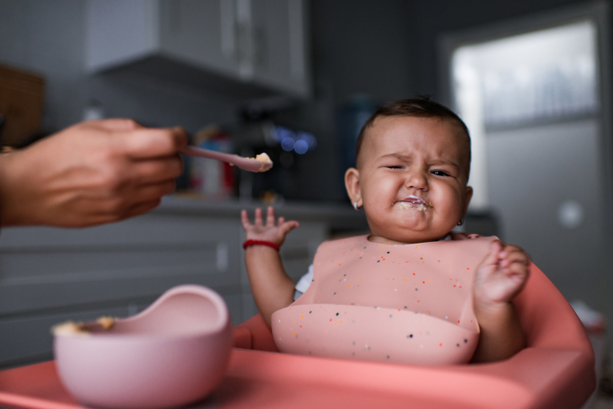 A baby making a face to indicate they don&#x27;t like their food