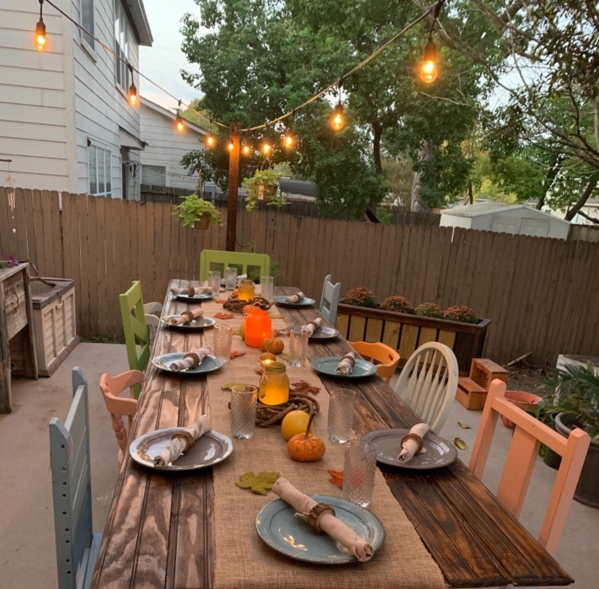 a reviewer photo of the lights hung over an outdoor dining table