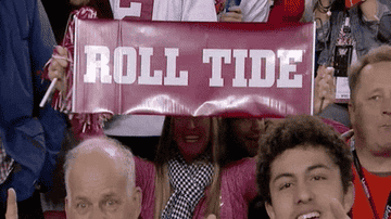 A woman flashing a Roll Tide sign