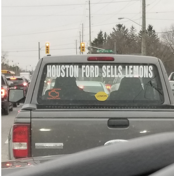Sign in back window of car: &quot;Houston Ford Sells Lemons&quot;