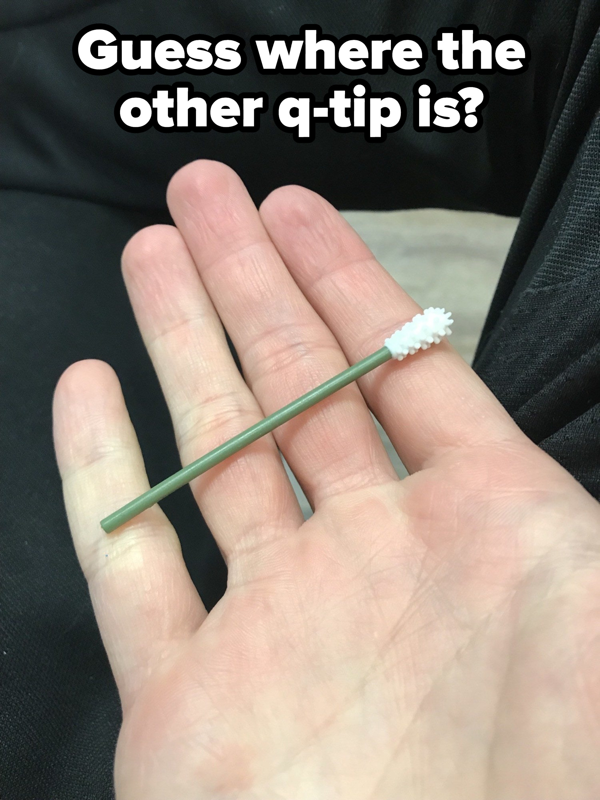 A hand holding a Q-tip