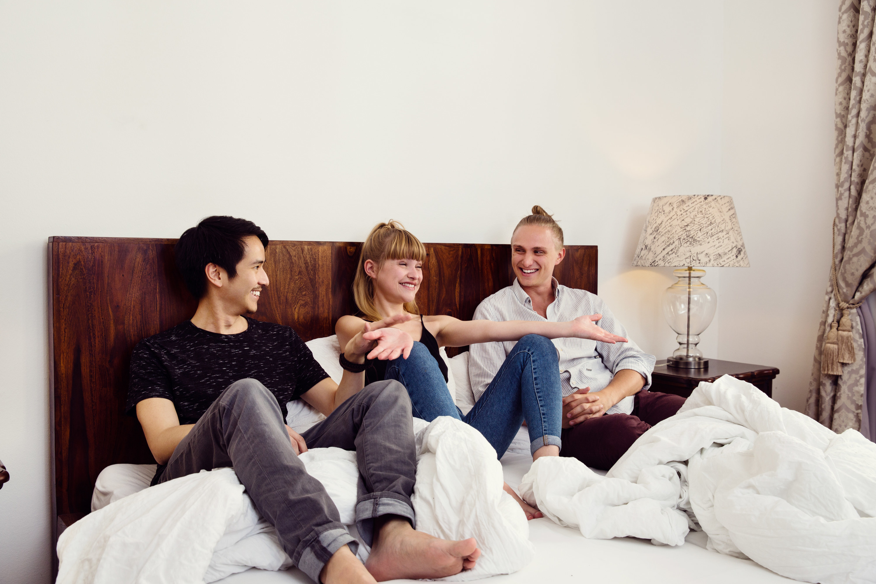 Three dressed people sitting in bed