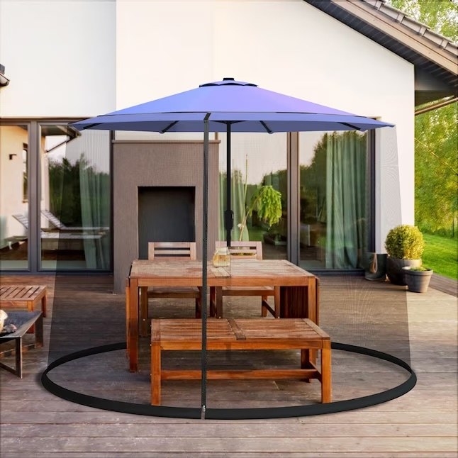 a black mosquito net around a table and chairs on a patio