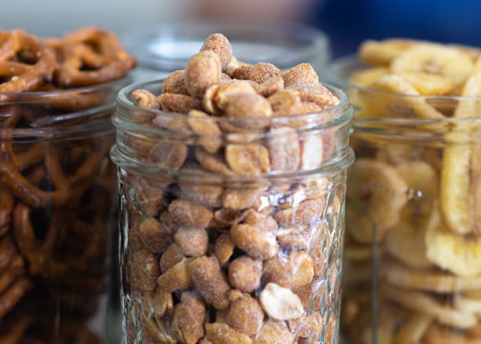 Peanuts, Pretzels, and Dried Banana Chips stored in glass jars