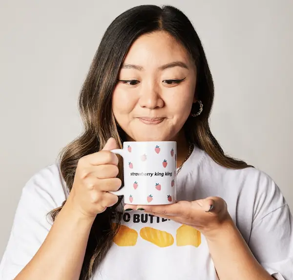 Jasmine Pak holding a coffee mug that says &quot;strawberry king king&quot;