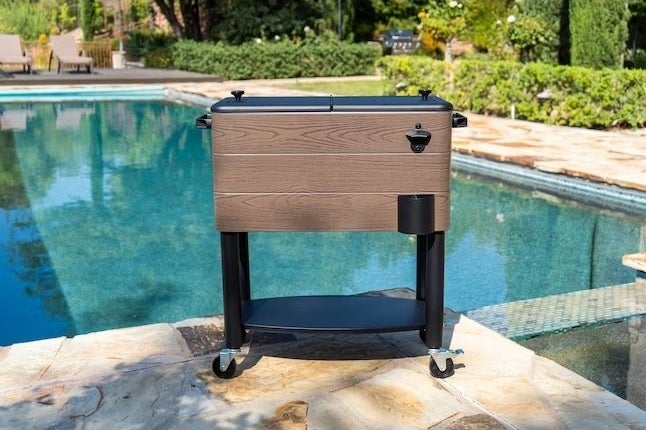 a portable cooler on wheels next to a pool