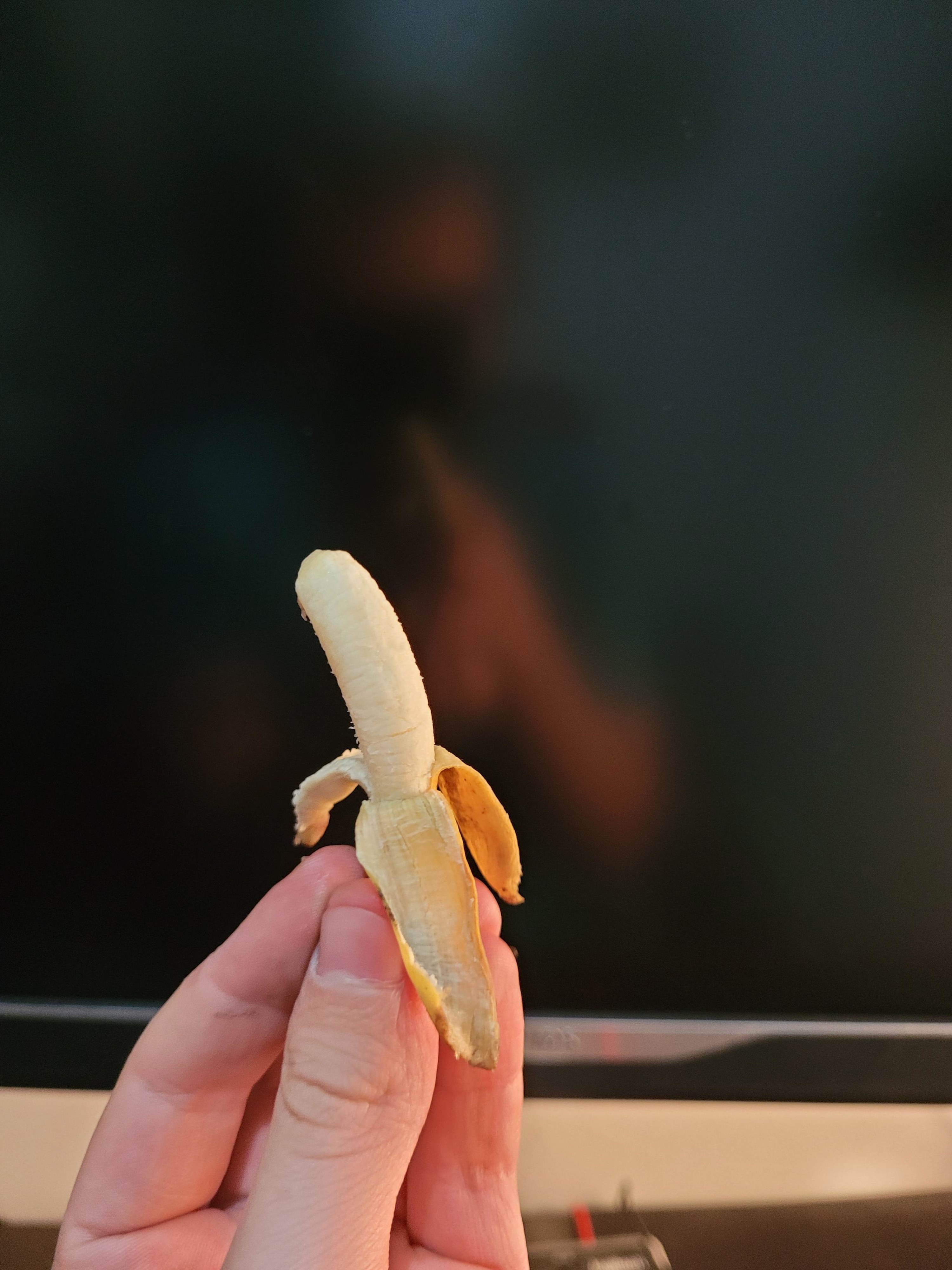 A hand holding a tiny banana