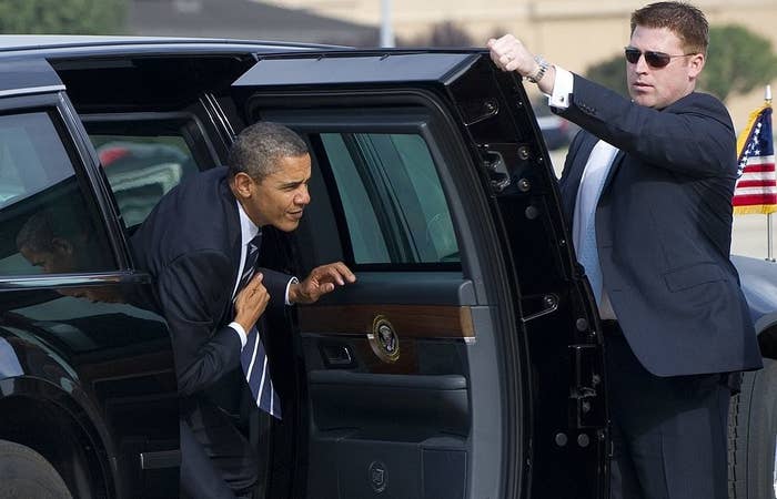 A Secret Service agent opening a car door for Barack Obama