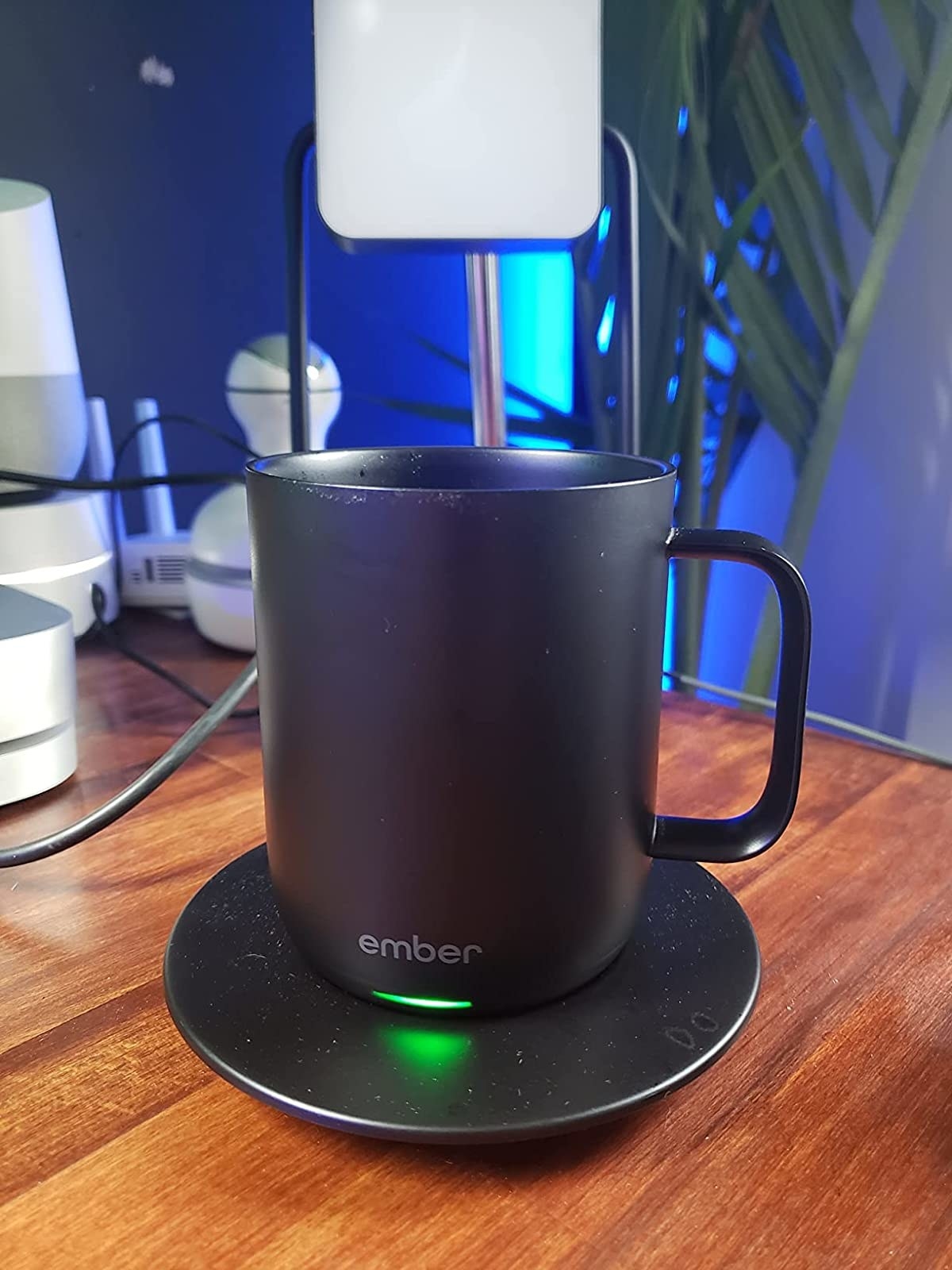 Reviewer&#x27;s black ember mug on charging plate with green light on