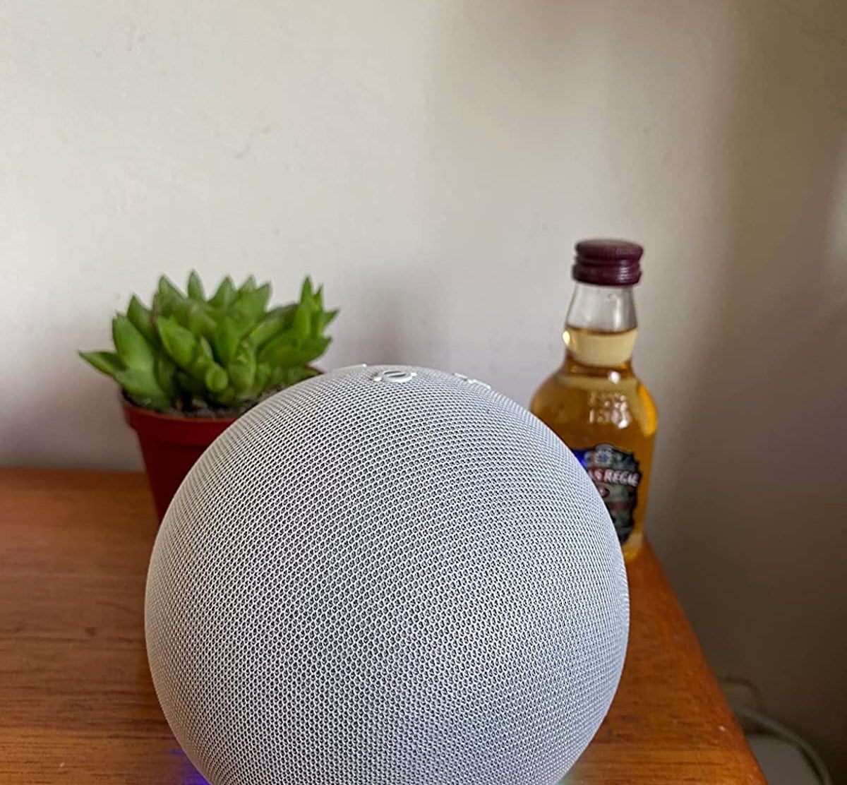 The white Echo Dot speaker on table