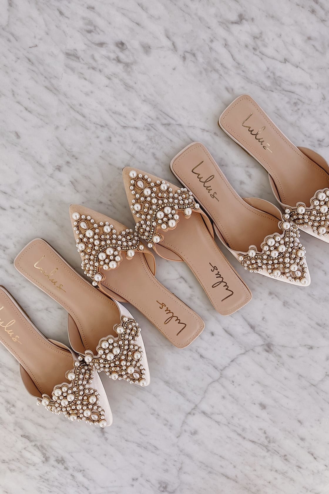 A pair of white and beige shoes with pearls all over them