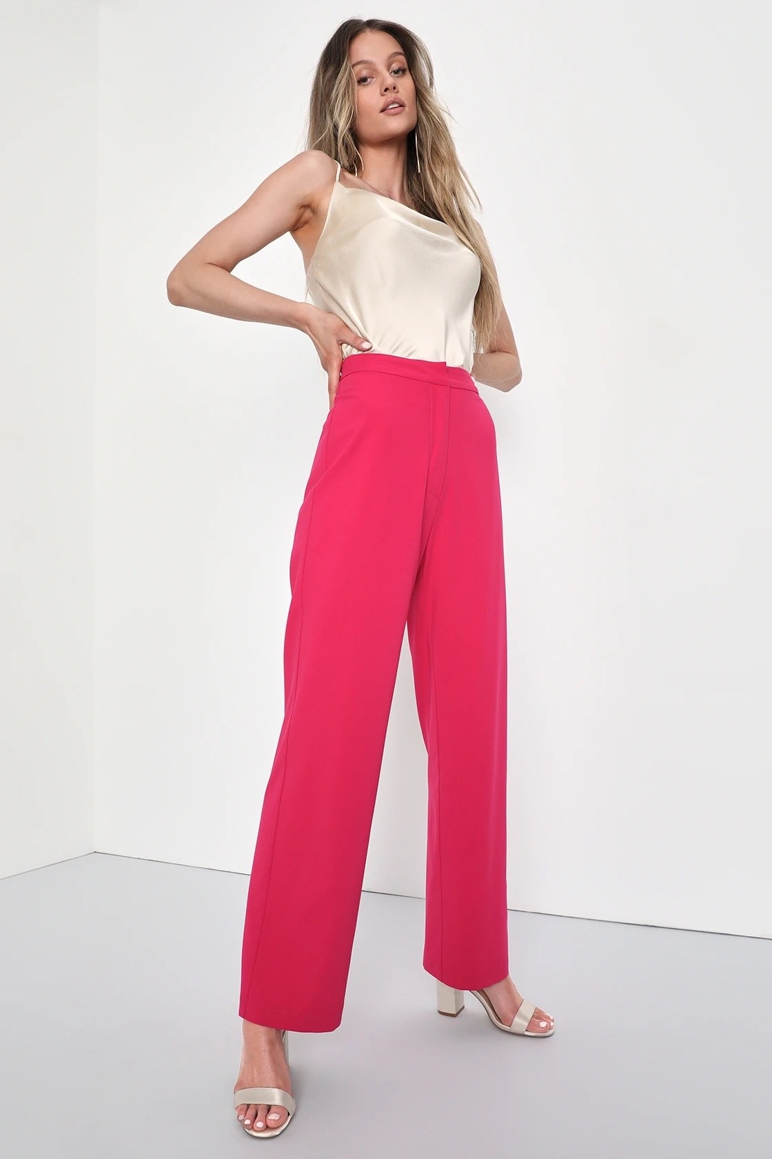 A model wearing a white camisole with pink trousers and champagne shoes