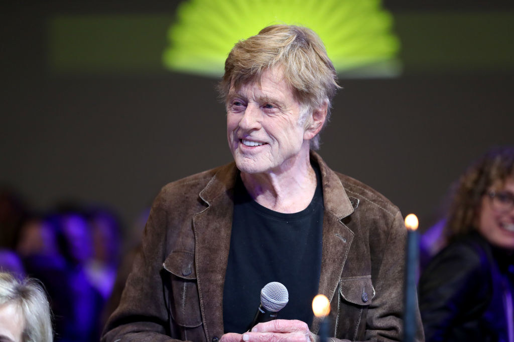 Robert Redford holding a microphone