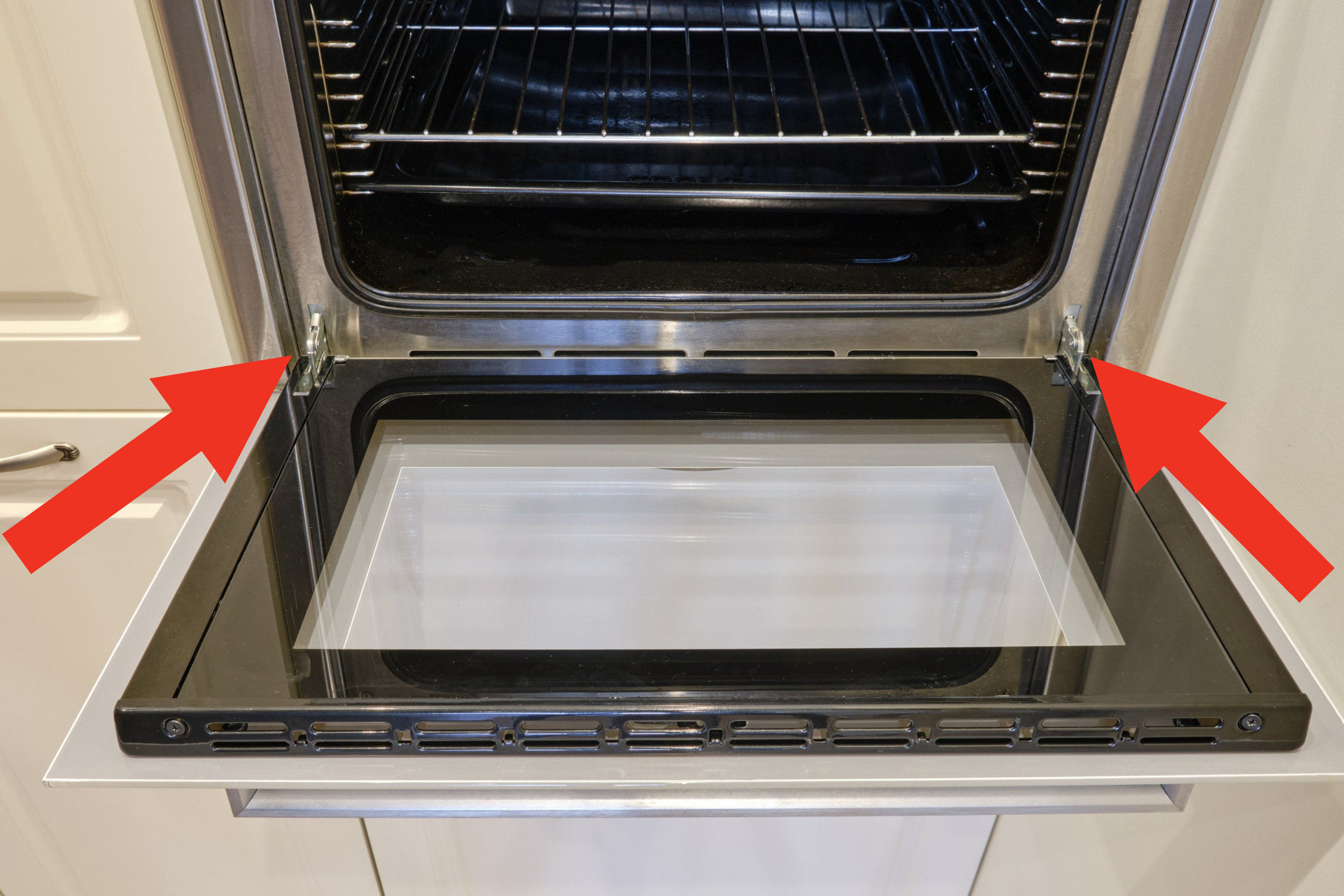 An opened oven with arrows pointing to the side of the oven door