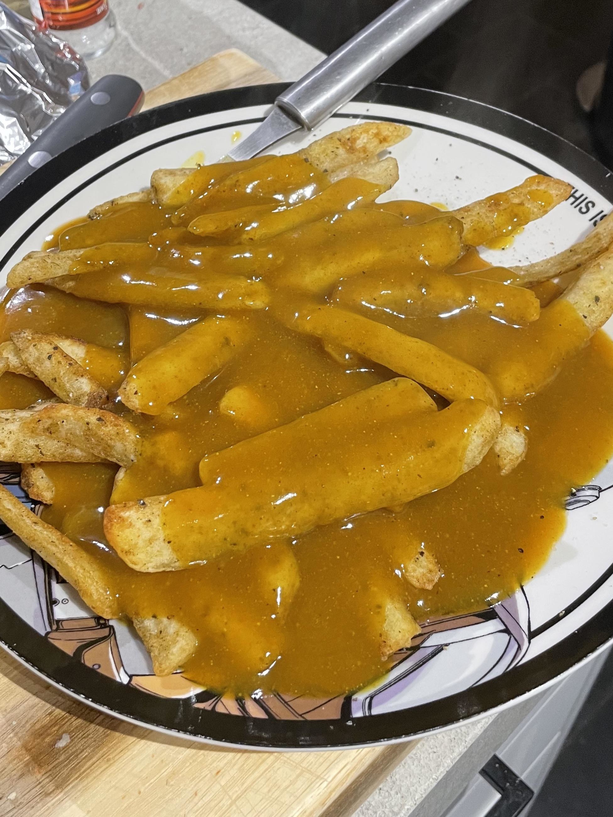 fries covered in a golden curry sauce