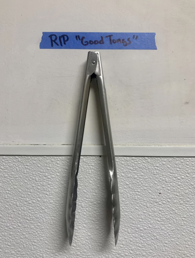 "RIP 'good tongs'" note above a pair of tongs hanging on the wall