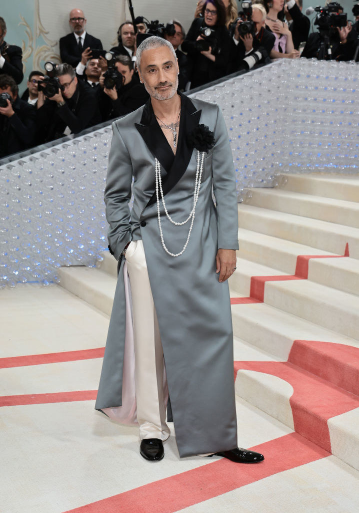Taika Waititi at the Met Gala in a grey suit with white pants