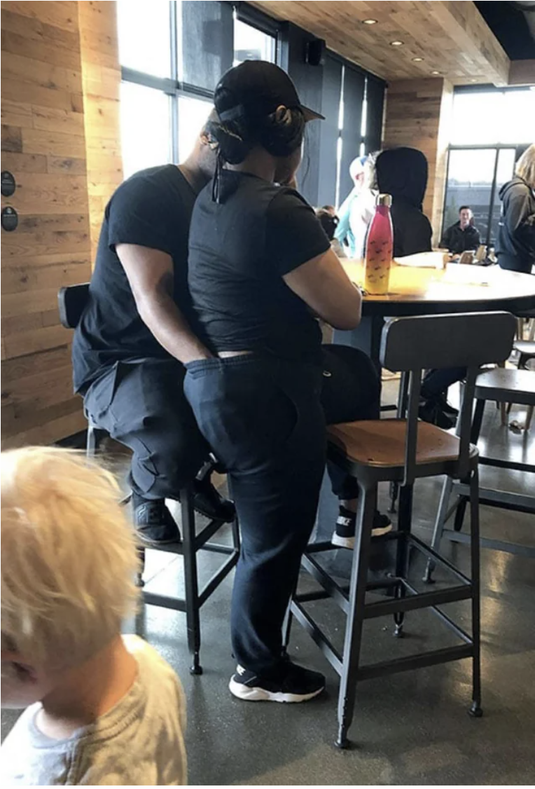 man with his hands in his girlfriend&#x27;s pants in a restaurant