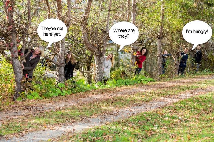People peek out from behind trees lining a path