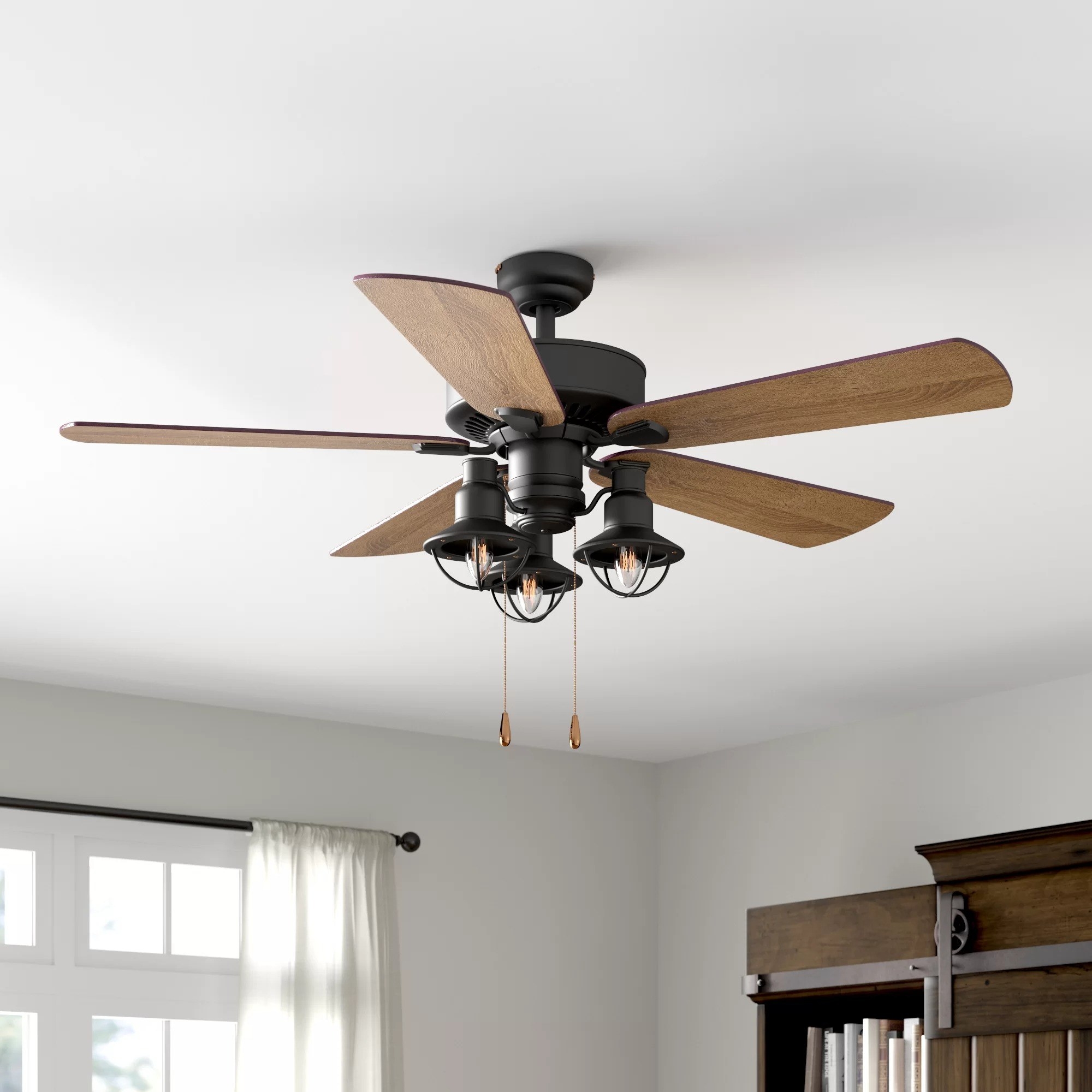 The ceiling fan with five blades and three lightbulbs in a living