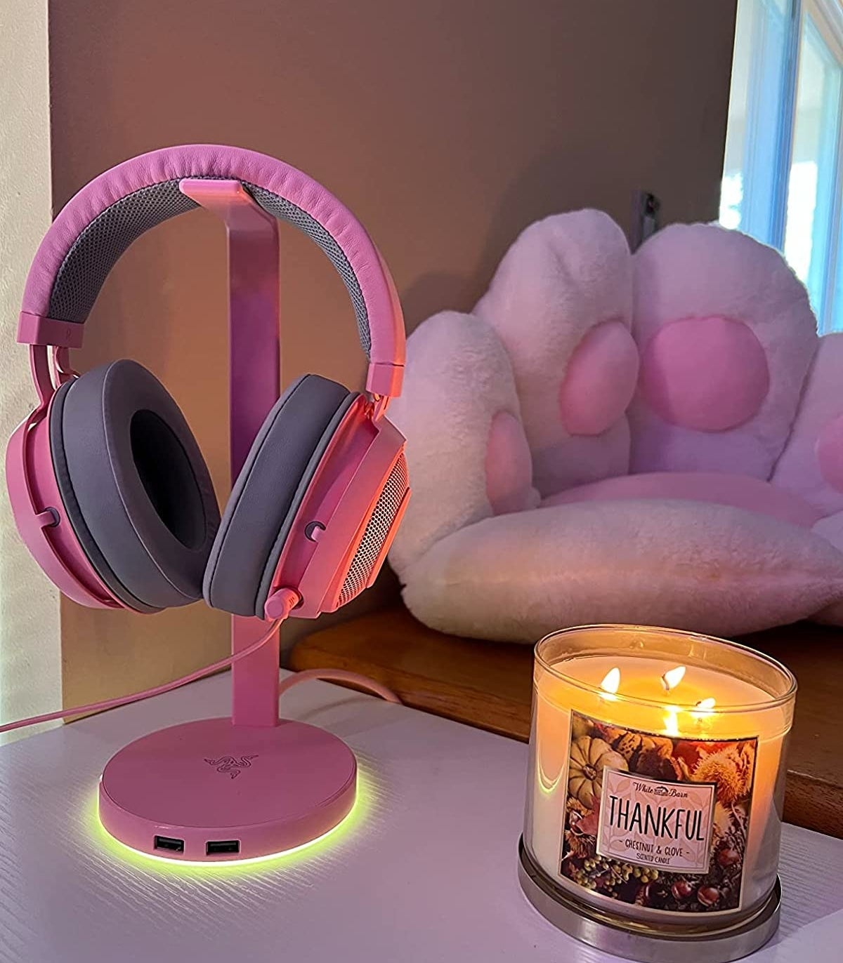pink headphones on the headphones stand that&#x27;s glowing at the base
