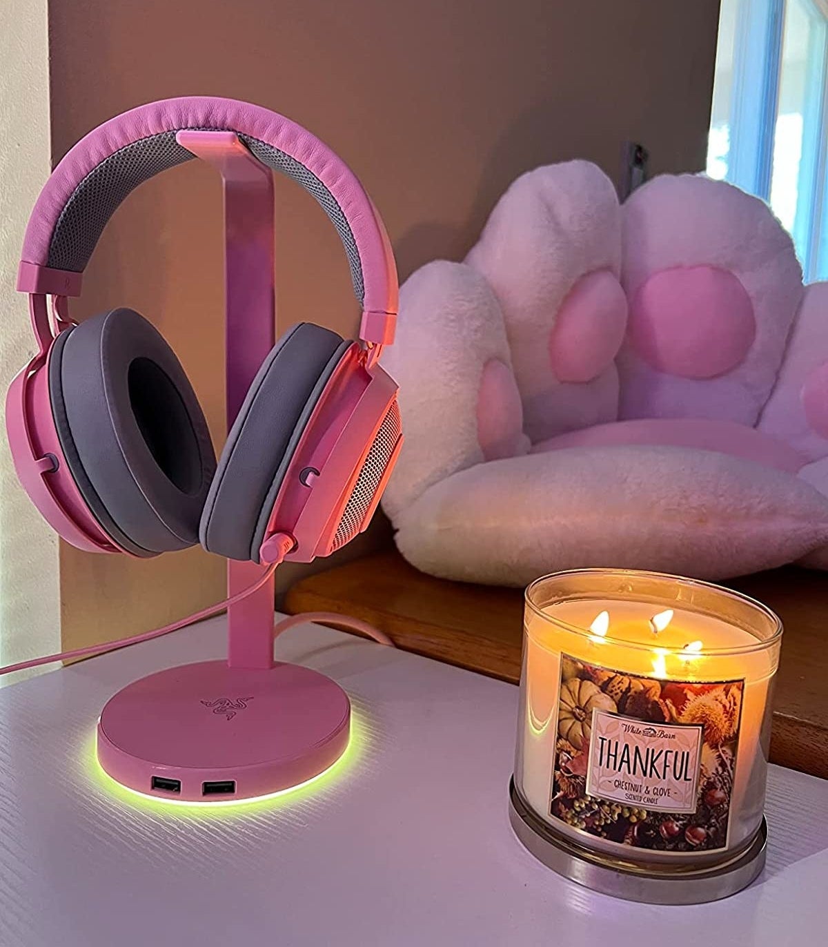 pink headphones on the headphones stand that&#x27;s glowing at the base