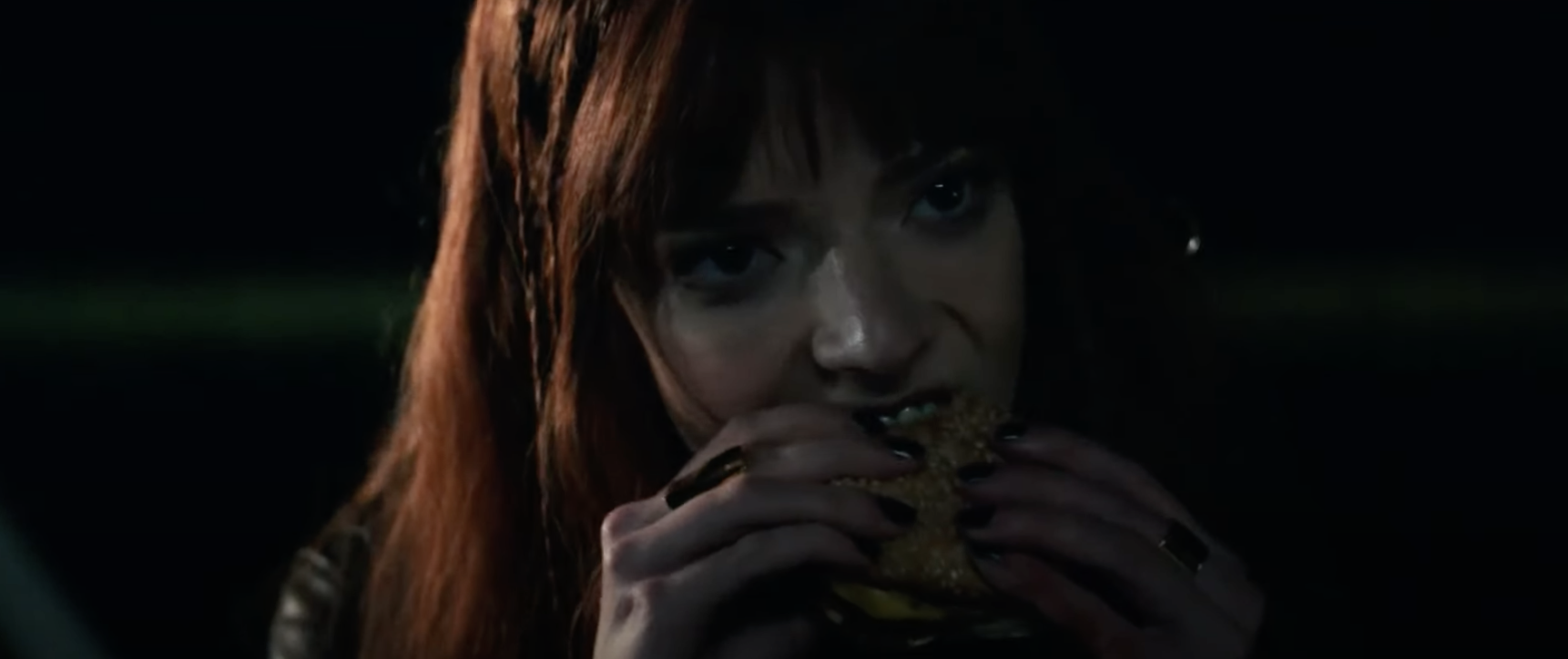 A woman eats a cheeseburger