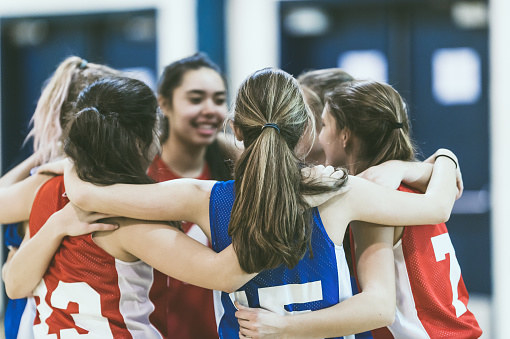 A high school basketball team hugging