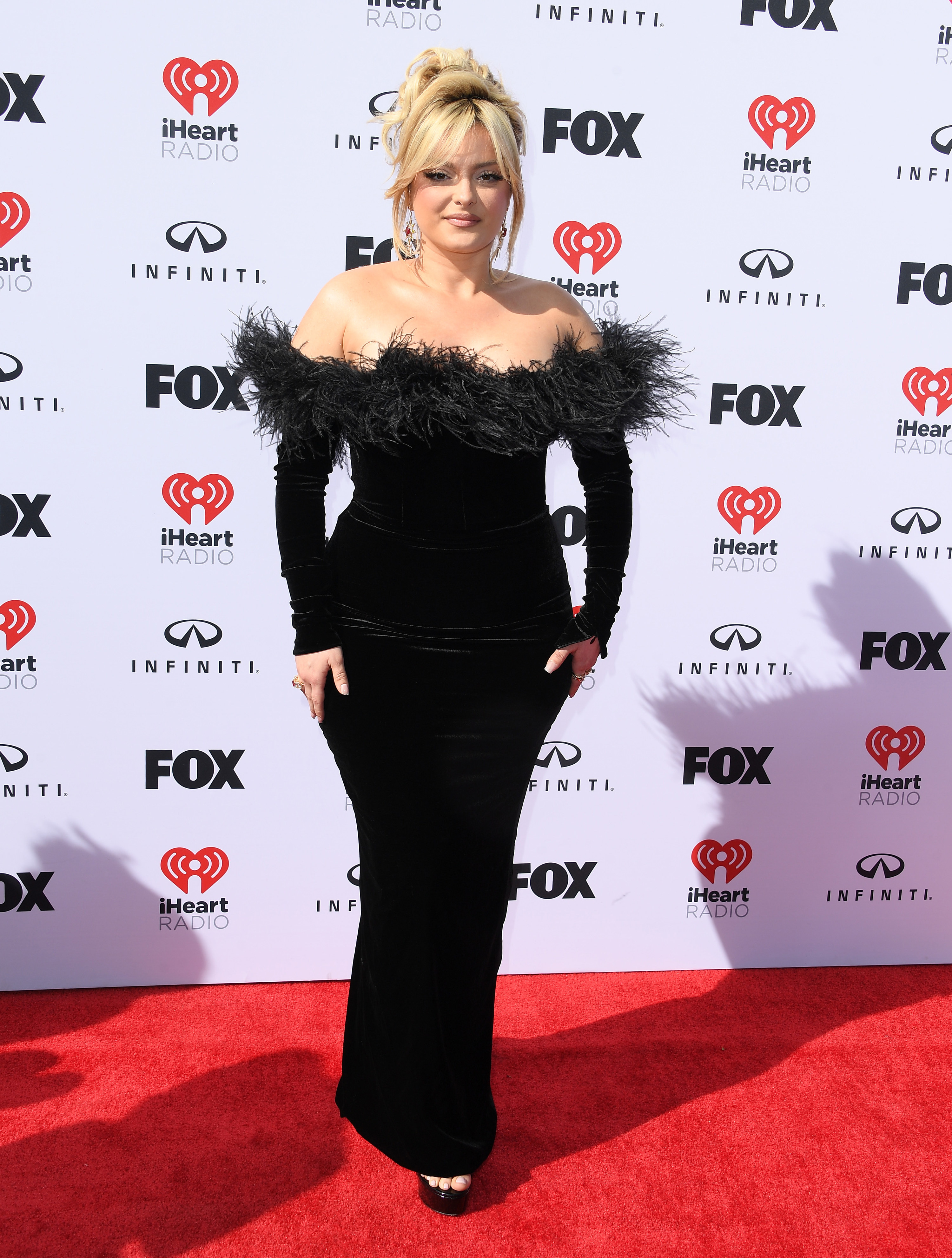 Bebe Rexha on the red carpet in an off-the-shoulder gown with feathers