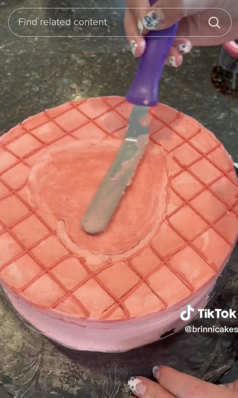 Brinni Cakes&#x27; TikTok using an offset spatula to spread icing