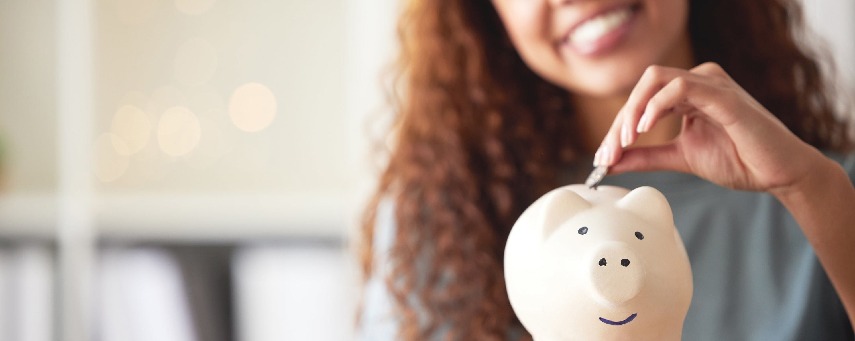 hand putting money into a piggy bank