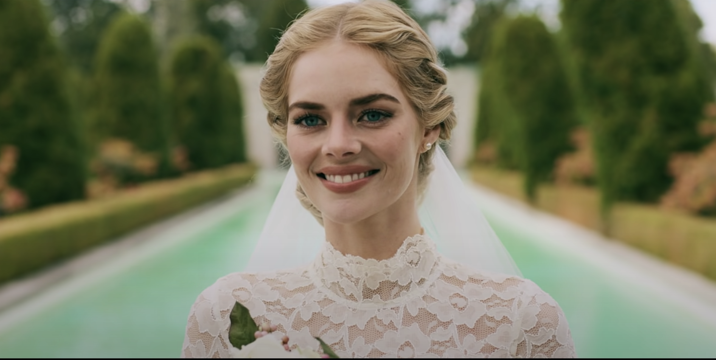 A woman in a wedding dress smiles to someone off-camera