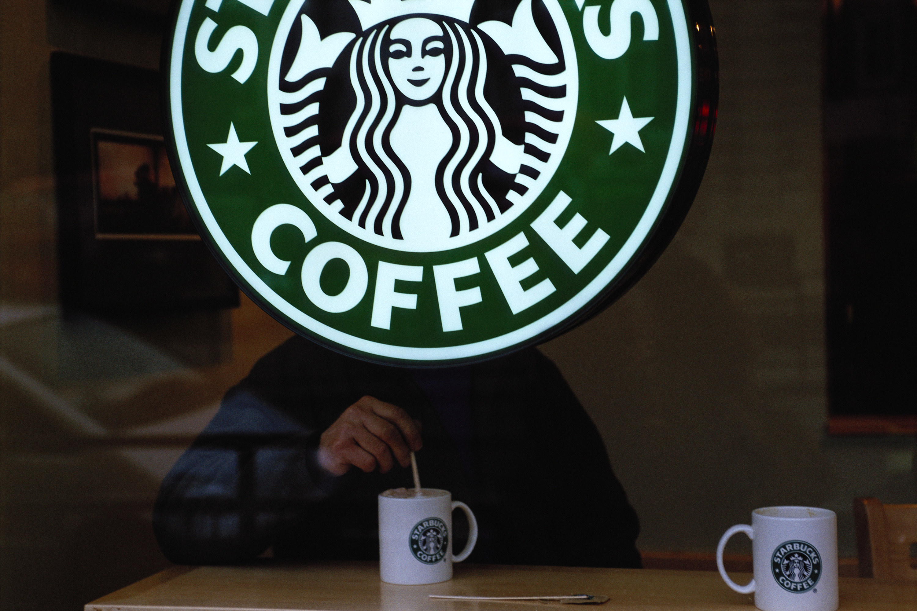 星巴克标志与某人搅拌一杯咖啡