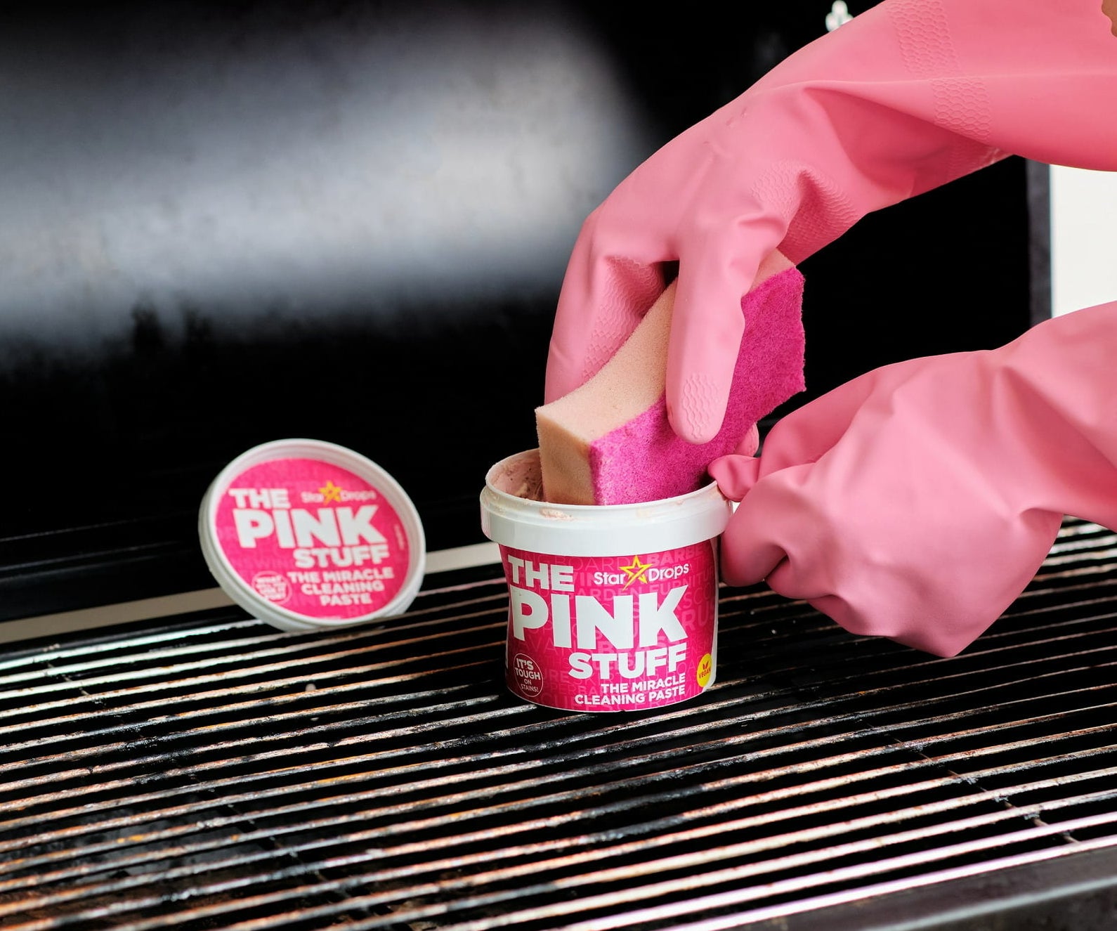 Model using the Pink Stuff on a grill with a sponge