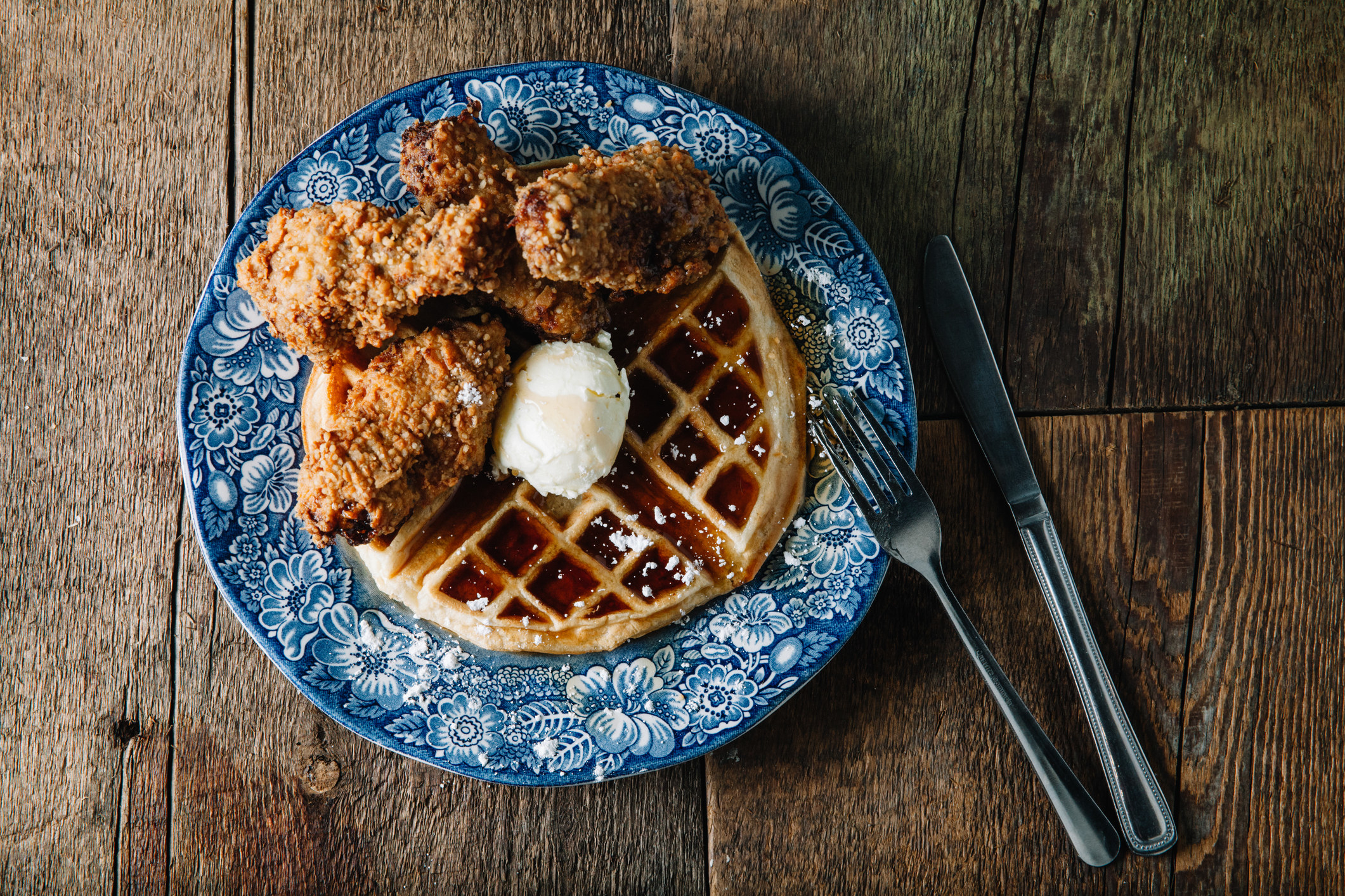 Chicken wings and waffles served with butter.