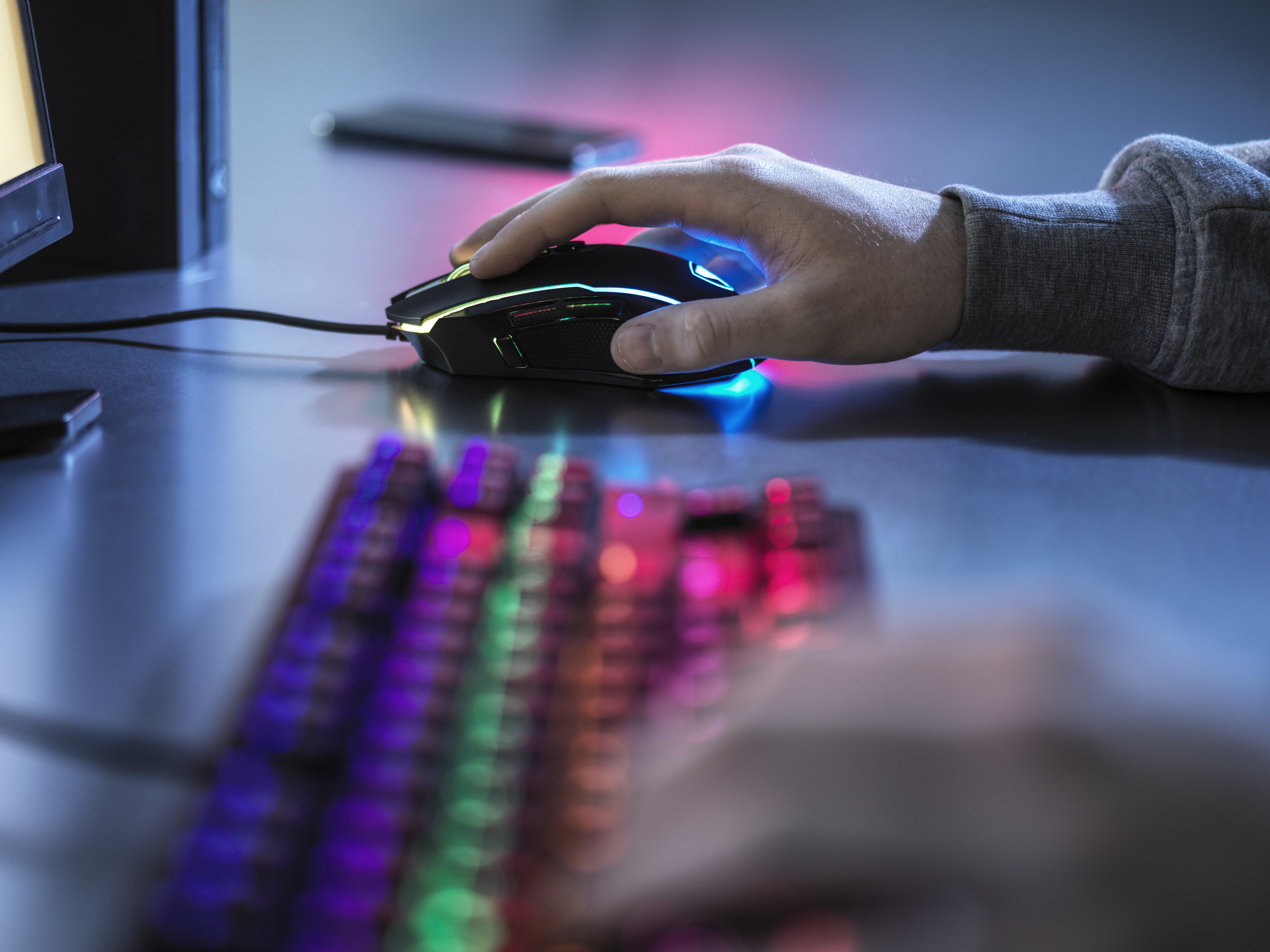 A person uses a gaming keyboard and mouse