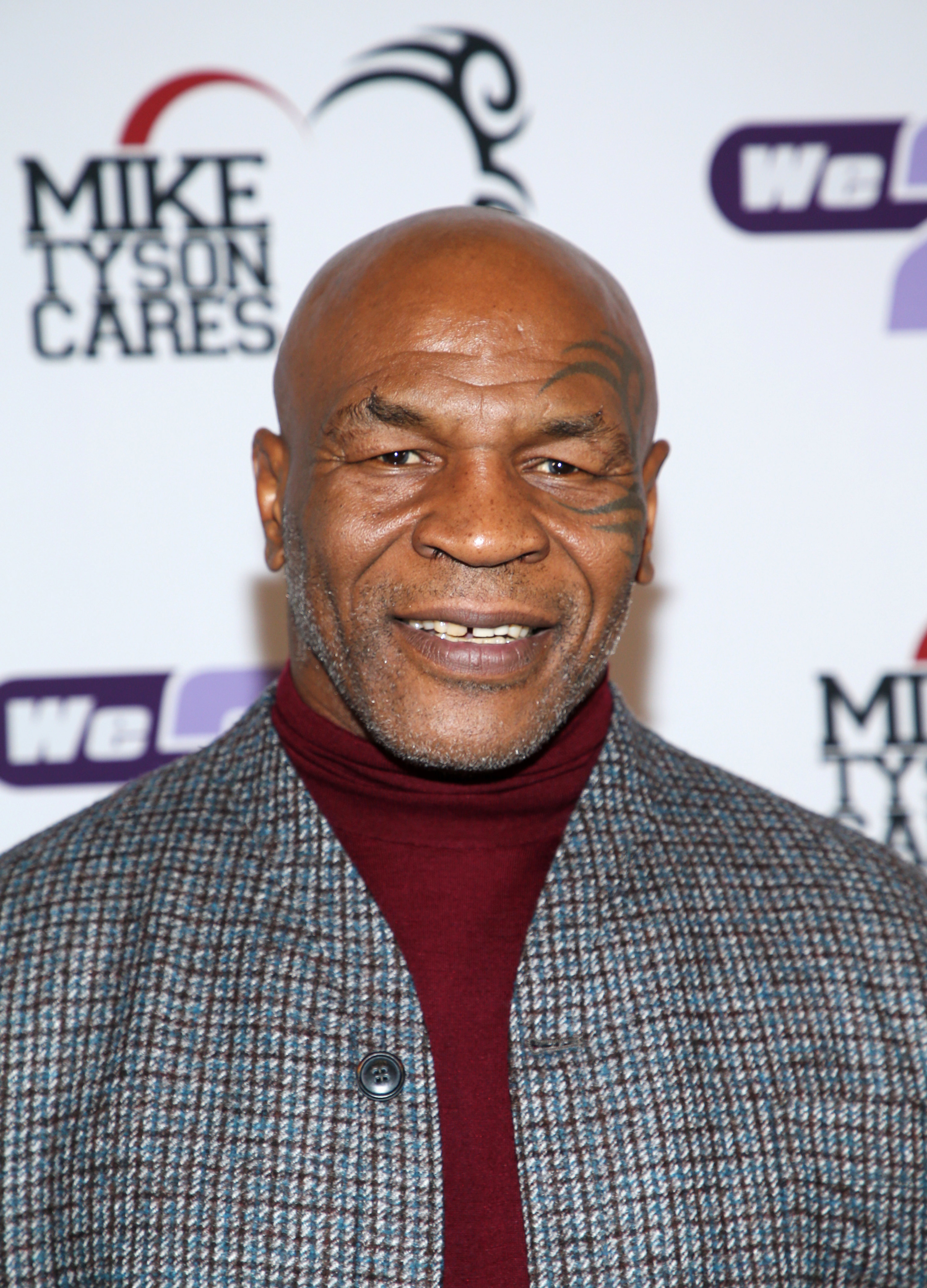 Mike Tyson smiling on a red carpet