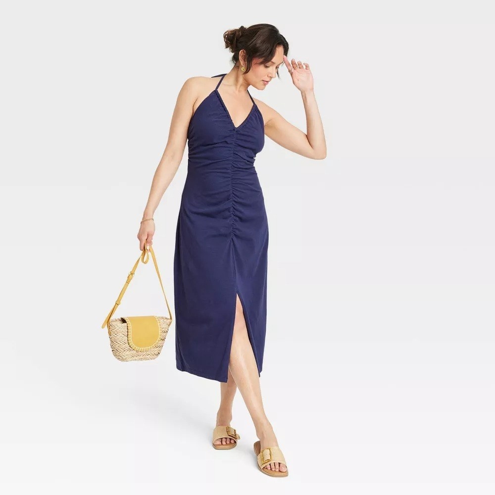 A model in the navy blue halter midi dress
